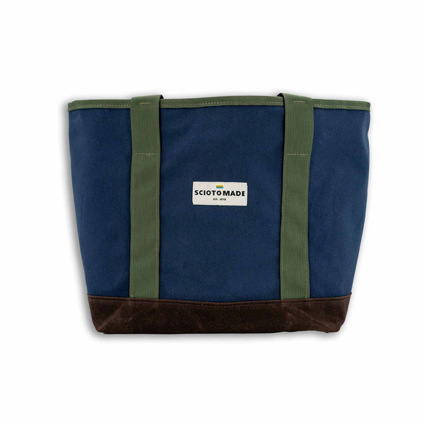 Front view of the Darby Tote: Featuring navy duck cloth and brown waxed canvas bottom, complemented by durable olive webbing straps.