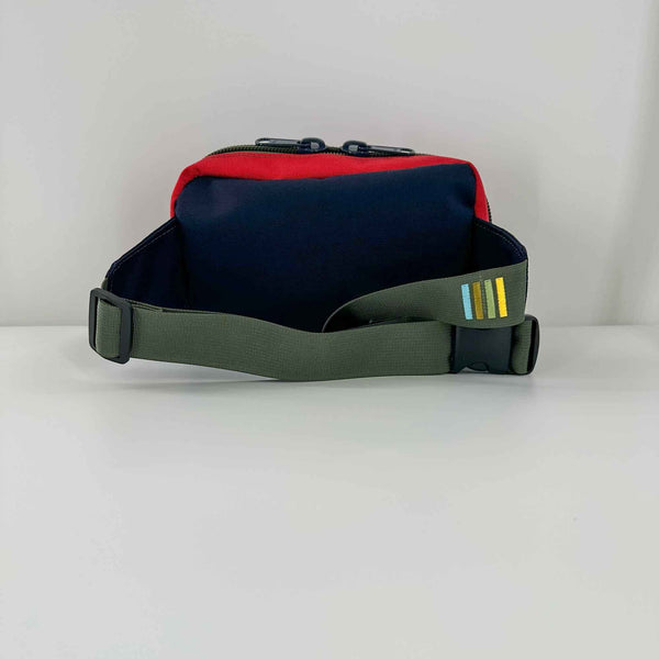 Lane sling bag is navy and red 1000D Cordura with Olive straps and attachment loops. Back view.