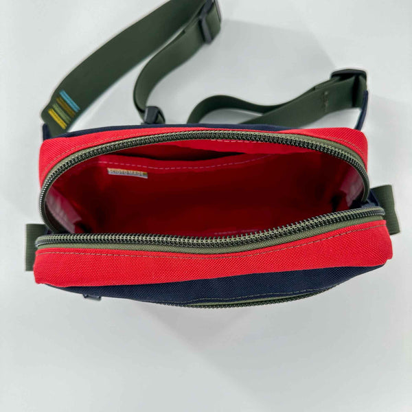Lane sling bag is navy and red 1000D Cordura with Olive straps and attachment loops. Inside view showing red pocket.