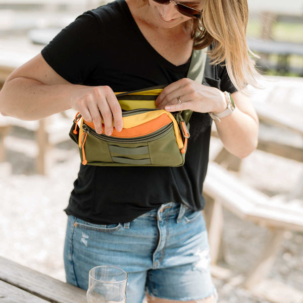 Women wearing Lane Sling bag. The Lane Sling Bag - where durability meets functionality for your everyday journey. Handcrafted with durable olive, orange and yellow 1000D Cordura this sling bag will last years to come.