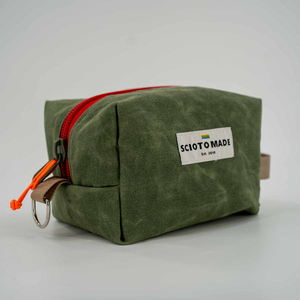 Travel Dopp Kit in green waxed canvas side view showing red zipper.