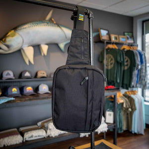 Made in ohio at The Shop, the city sling bag is shown hanging from a pipe fixture.