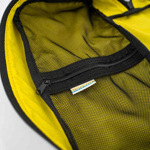 Inside view of the 4L packing cube.  Showing interior zipped mesh pockets.  Yellow interior with black mesh.