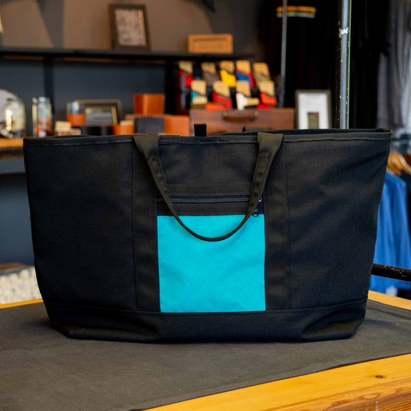 Scioto Made Boat Tote.  Outside colors black main body and teal pocket.  Interior color is teal.  Shown in the shop.