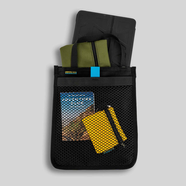 Scioto Made iPad Sleeve. Features outside mesh pocket and bright teal interior. All black exterior with teal pull tab for mesh pocket.  Carrying handle on top.  Size 10" x 12".  Shown with iPad, mini and small accessory bags and adventure book. 